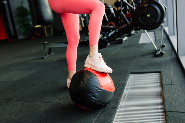 Piękna kobieta trenuje pilates z piłką w siłowni