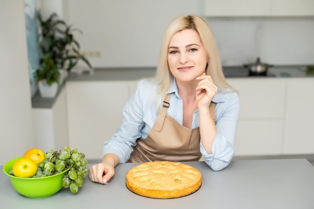 Piękna kobieta trzyma ciasto w kuchni