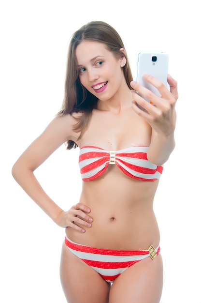 Piękna kobieta w bikini robi selfie na swoim telefonie