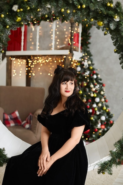 Piękna kobieta w czarnej sukni na Boże Narodzenie