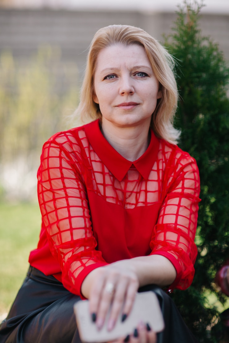 Zdjęcie piękna kobieta w czerwonej bluzce. zmarszczki na twarzy kobiety. blondynka w czerwonej bluzce. dobrze wyglądająca mama