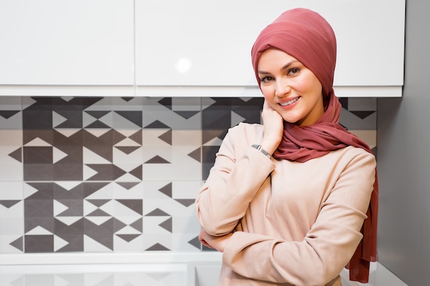 Piękna kobieta w czerwonym hidżabie w kuchni copyspace