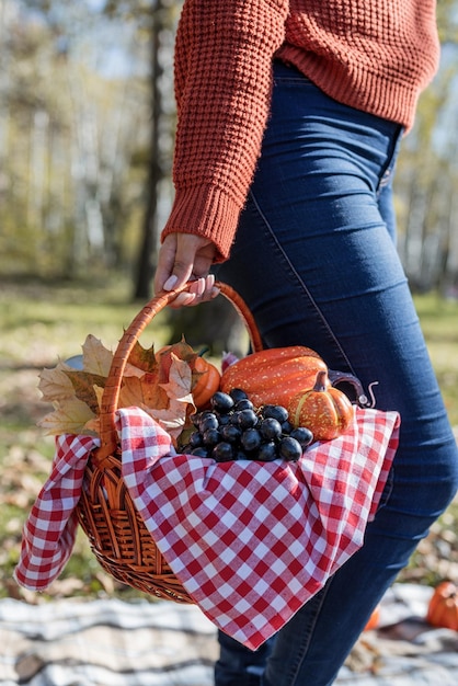 Piękna kobieta w czerwonym swetrze na pikniku w jesiennym lesie