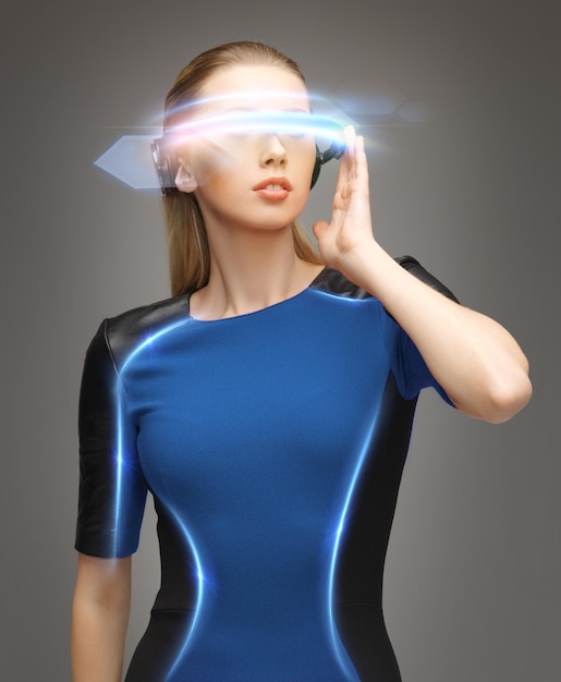 Zdjęcie piękna kobieta w futurystycznych okularach i niebieskiej sukience