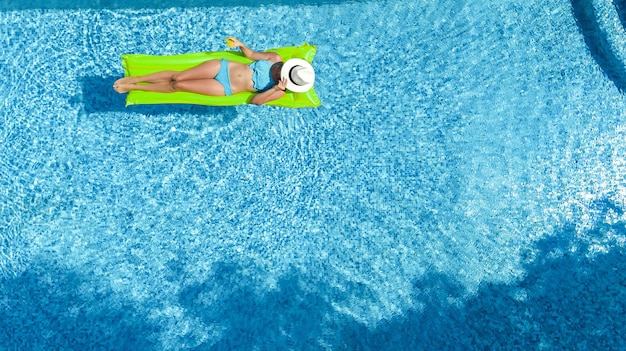 Piękna kobieta w kapeluszu w basenie z lotu ptaka widok z góry młoda dziewczyna w bikini relaksuje
