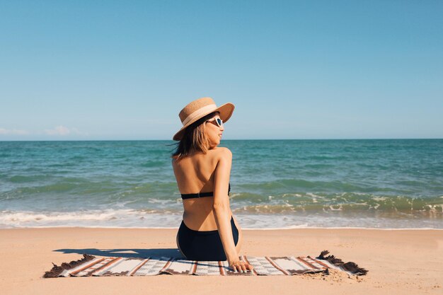 Piękna kobieta w seksownych kostiumach kąpielowych podróżuje po tropikalnej plaży