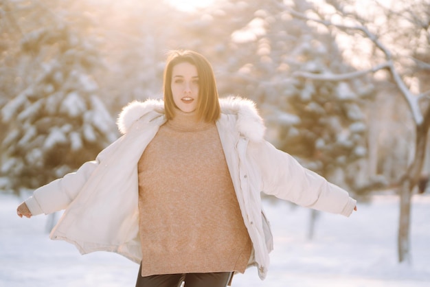 Piękna kobieta w zaśnieżonym parku Młoda dama spacerująca w słoneczny zimowy dzień