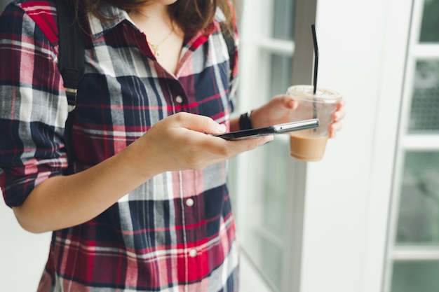 Zdjęcie piękna kobieta z azji używa smartfona w centrum miasta do wyszukiwania