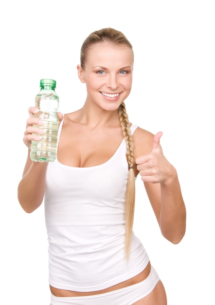 piękna kobieta z butelką wody na białej ścianie