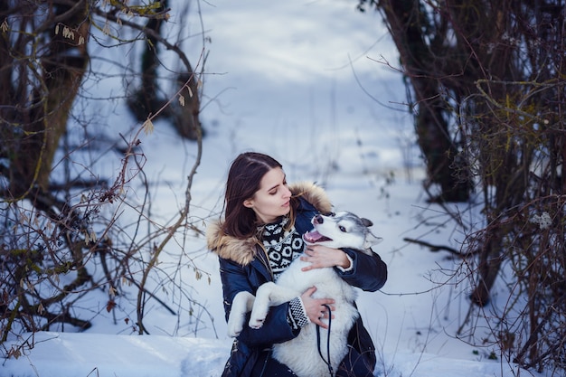 Piękna kobieta z husky pozowanie w zimie