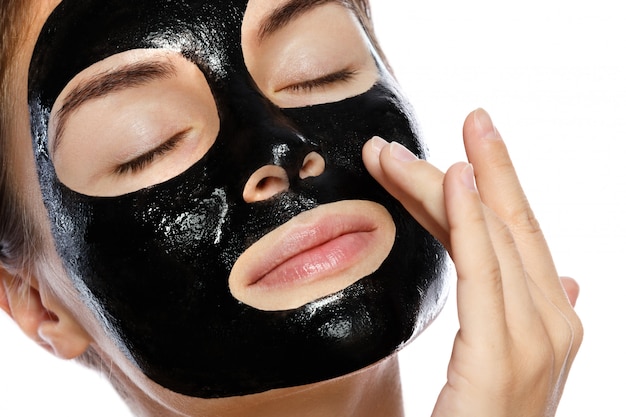 Zdjęcie piękna kobieta z oczyszczającą czarną maską na twarzy