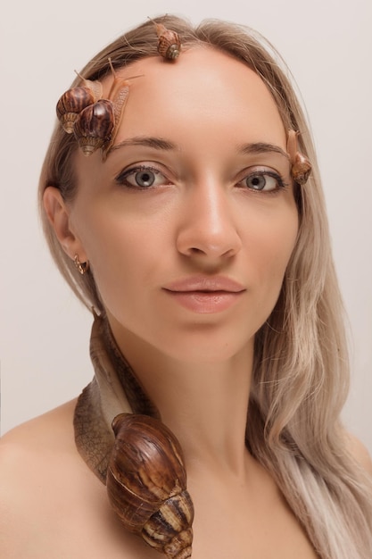 Piękna kobieta z ślimakami na twarzy Procedura kosmetyczna odmłodzenie skóry