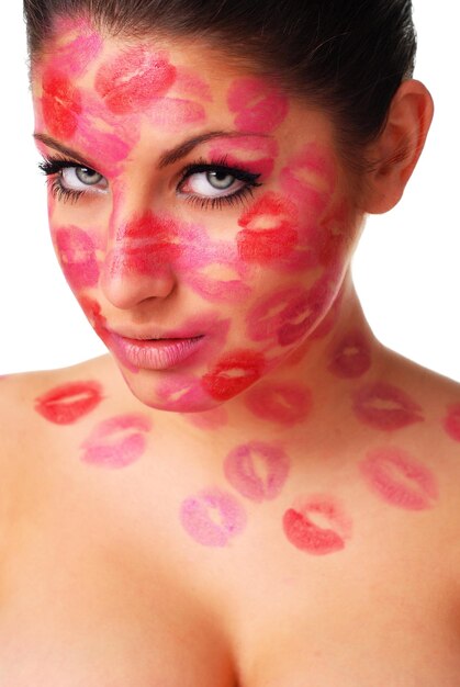 piękna kobieta ze znaczkami czerwonej szminki na twarzy