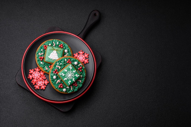 Piękna kompozycja świąteczna składająca się z talerzy ceramicznych z piernikami i innymi elementami dekoracji noworocznych na ciemnym betonowym tle