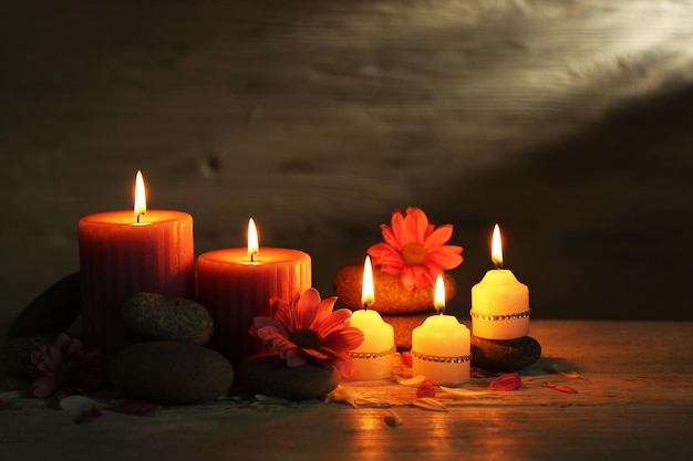 Piękna kompozycja ze świecami i kamieniami spa na drewnianym tle