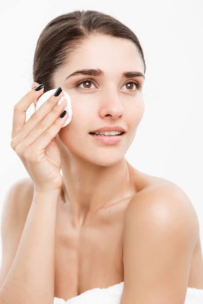 Piękna koncepcja pielęgnacji skóry - piękna kobieta rasy kaukaskiej twarzy. Piękne piękno młodych kobiet modelu dziewczyna gładkie czyszczenie twarzy na białym tle.