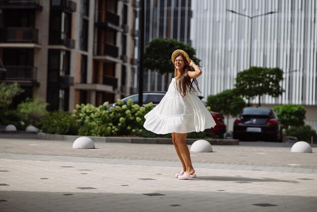 Piękna ładna kobieta w białej sukni spacerująca po ulicy miasta