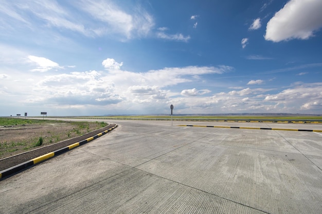 piękna letnia autostrada krajobrazowa i zielone pole z błękitnym niebem z białymi chmurami