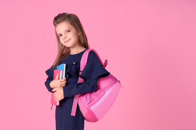 Piękna mądra dziewczyna z notebookiem na sobie strój mundurka szkolnego i różowy jasny plecak