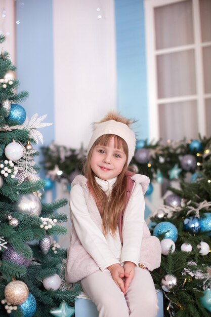 Piękna mała dziewczynka na tarasie udekorowanym na Boże Narodzenie