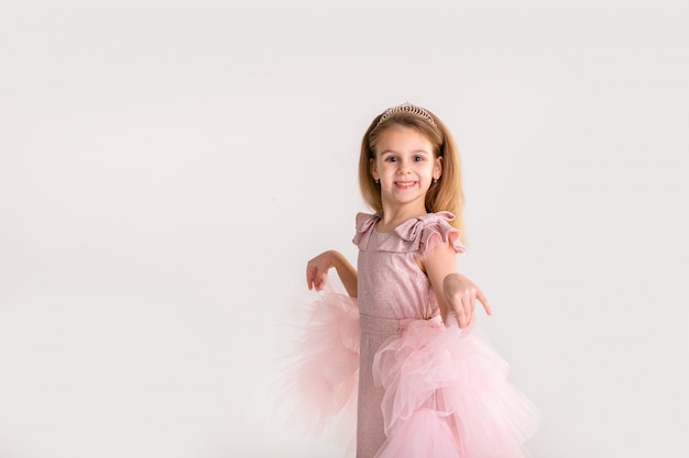 Piękna mała księżniczka tańczy w luksusowej różowej sukience