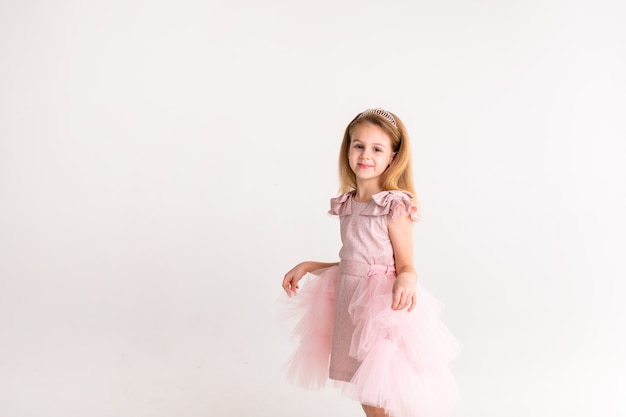 Piękna mała księżniczka tańczy w luksusowej różowej sukience