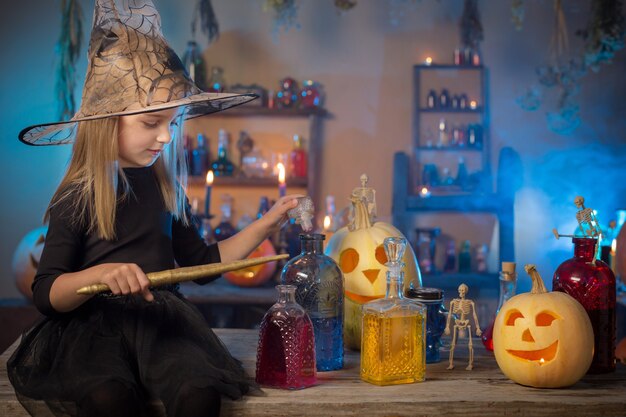 Piękna mała wiedźma z dekoracjami na Halloween