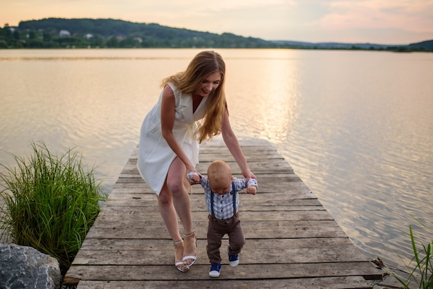 Piękna mama i jej syn bawią się nad jeziorem