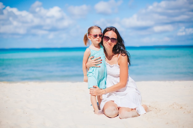 Piękna matka i córka na plaży, ciesząc się wakacjami