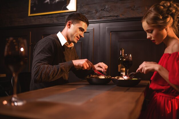 Piękna Miłość Para Jedzenie W Restauracji, Romantyczny Wieczór. Elegancka Kobieta W Czerwonej Sukience I Jej Człowiek Wolny Czas Razem