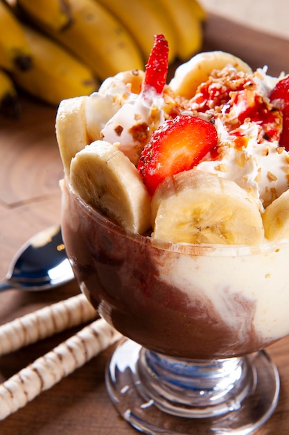 Piękna miska na lody ozdobiona truskawkami, bananami, kasztanami i bitą śmietaną