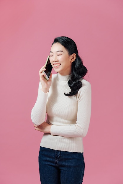 Piękna młoda azjatycka kobieta, która rozmawia przez telefon