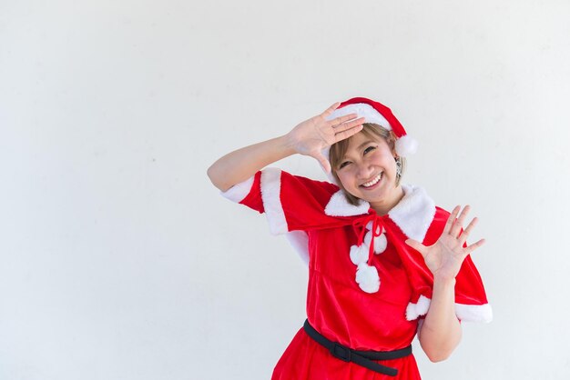 Piękna młoda azjatycka kobieta w Santa Claus ubrania na białym tleLudzie tajlandiiWysłane szczęście dla dzieciWesołych ŚwiątWitamy w zimieKoncepcja szczęśliwej kobiety