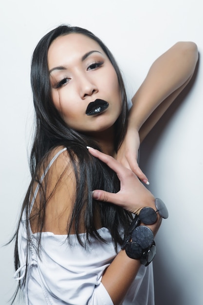 Piękna młoda azjatycka kobieta z idealną skórą i czarną szminką, sesja mody fashion