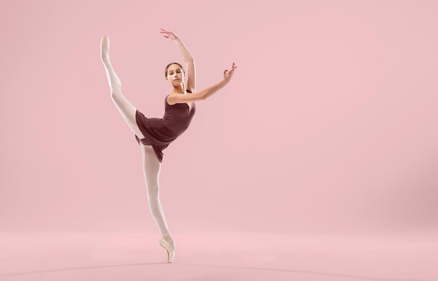 Piękna młoda balerina na białym tle Balerina jest ubrana w czerwony trykot różowe trykoty pointe shoes