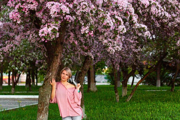 Piękna młoda dama w ogrodzie kwitnących wiśni