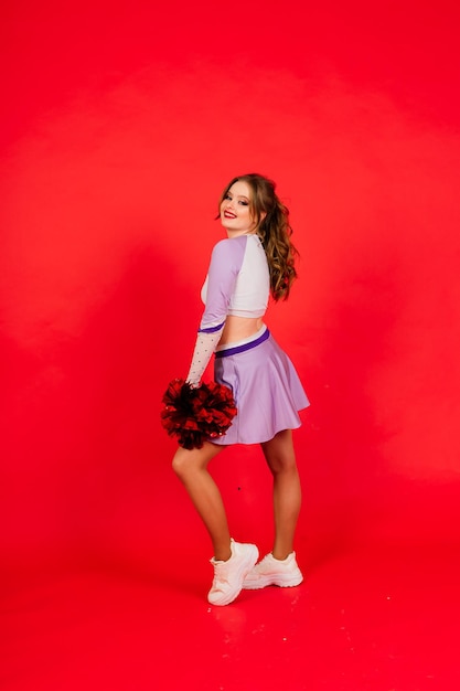 Piękna młoda dorosła kobieta cheerleaderka, studio czerwone i niebieskie tła