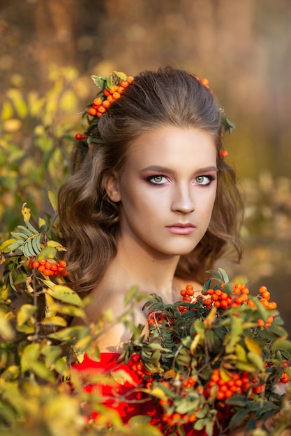 Piękna młoda dziewczyna jesienią z jagód jarzębina