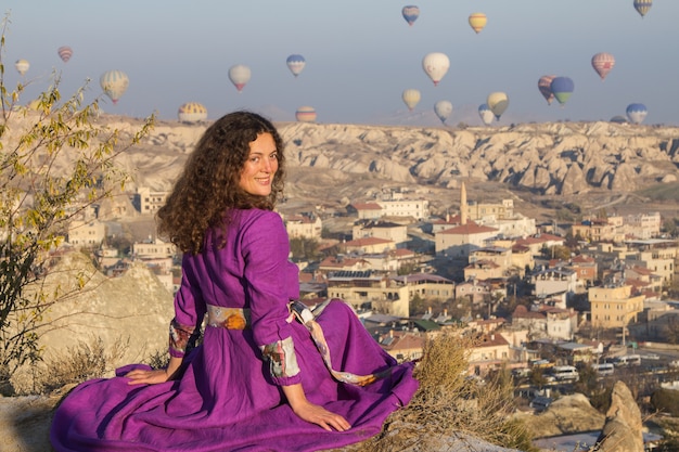 Piękna młoda dziewczyna patrzy na lot balonów w Cappadocia na punkt widzenia