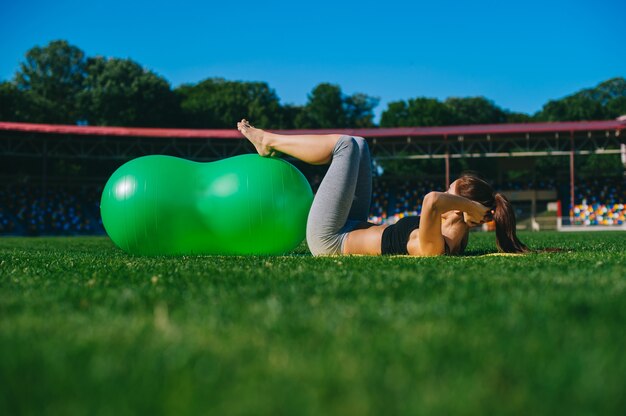 Piękna młoda dziewczyna robi ćwiczeniom z fitball