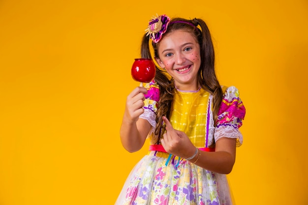 Piękna młoda dziewczyna w czerwcu imprezowe ubrania jedzący deser Love Apple Apple pokryty czerwonym karmelem