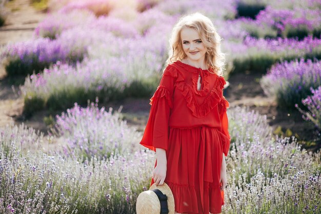 Piękna młoda dziewczyna w czerwonej sukience na lawendowym polu