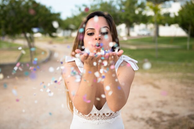 Piękna młoda dziewczyna w parku z confetti