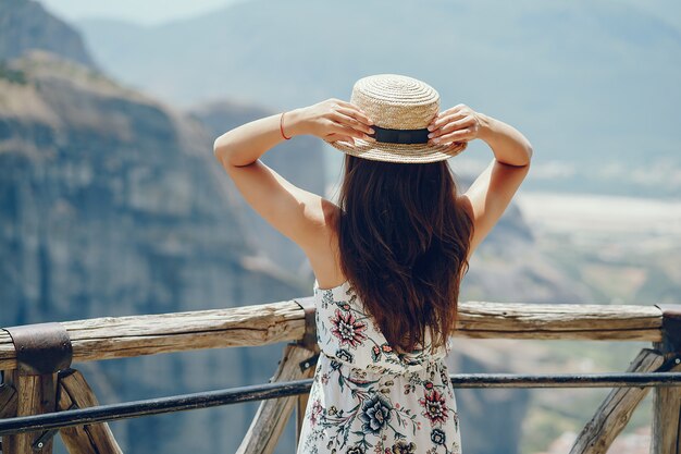 Piękna młoda dziewczyna w słomianego kapeluszu pozyci i patrzeć góry