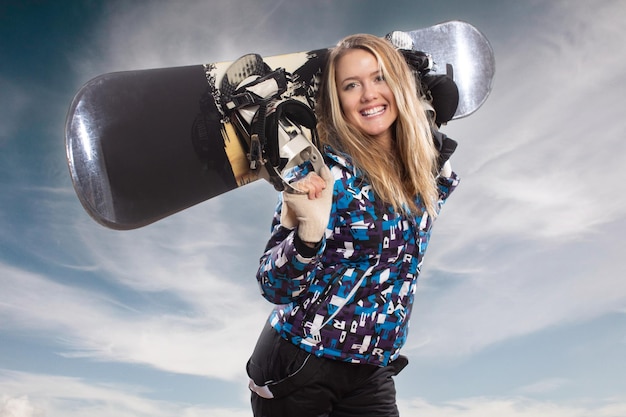 Zdjęcie piękna młoda dziewczyna z uśmiechem na snowboardzie