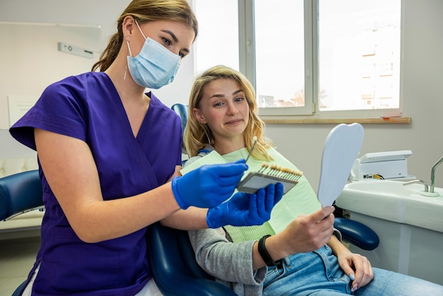 piękna młoda klientka, która odniosła sukces, zgłosiła się do dentysty na wybielanie zębów. Koncepcja wybielania zębów