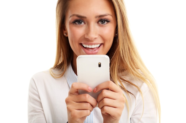Piękna młoda kobieta biznesu korzystająca z telefonu komórkowego na białym tle