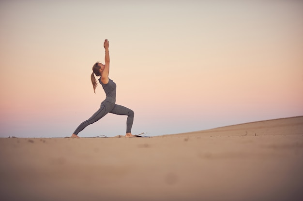 Piękna młoda kobieta ćwiczy asanę Virabhadrasana