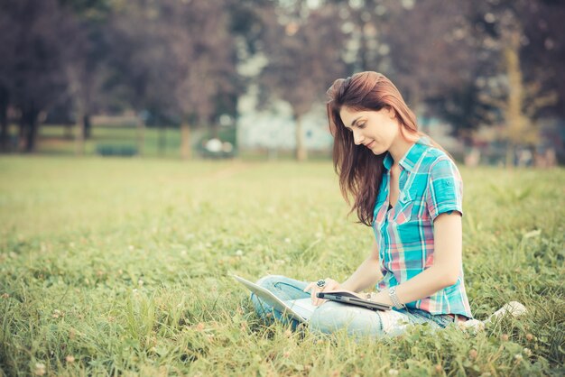 piękna młoda kobieta hipster za pomocą laptopa i tabletu