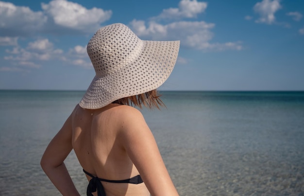 Piękna młoda kobieta na plaży w kapeluszu